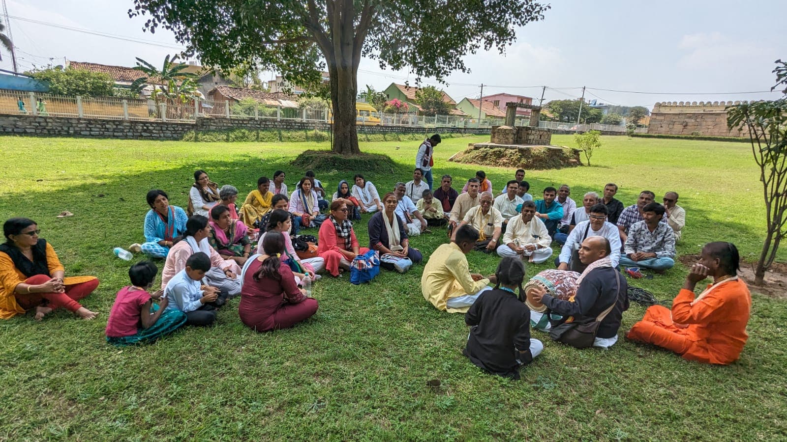 Devotees seated together for kirtan during a yatra
